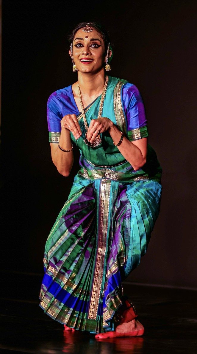 In a green and blue costume, mid-expression