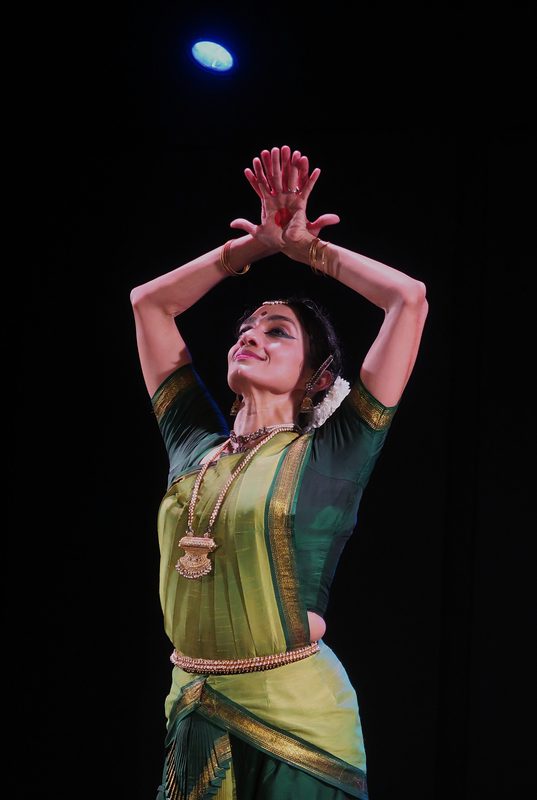 Green and yellow costume, arms raised